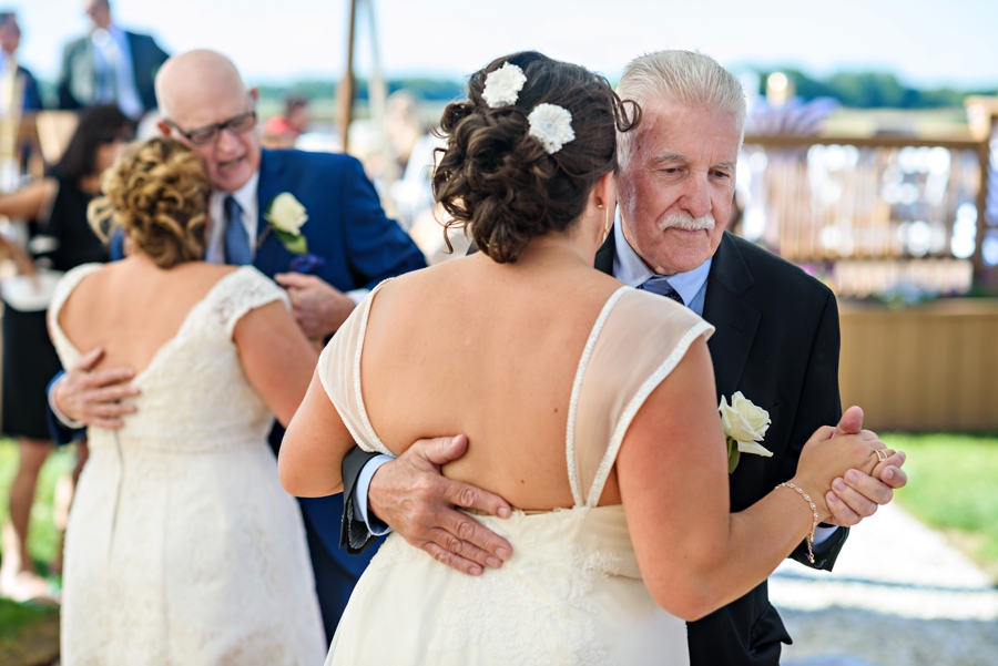 Two brides dance with their fathers during the wedding reception.
